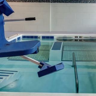 An indoor swimming pool equipped with an accessibility wheelchair lift for easy access.