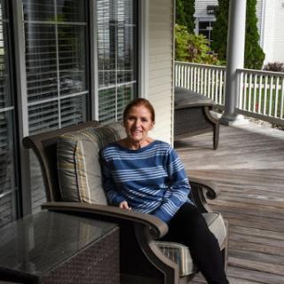A woman enjoying a moment of relaxation on a porch.