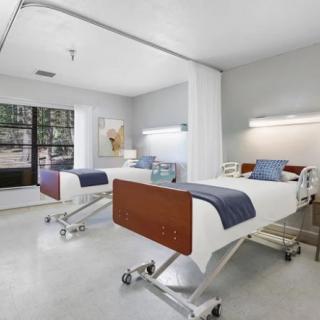 A modern hospital room with two clean and well-organized patient beds.