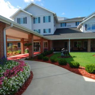 A well-maintained building with a landscaped entrance and flower beds on a sunny day.