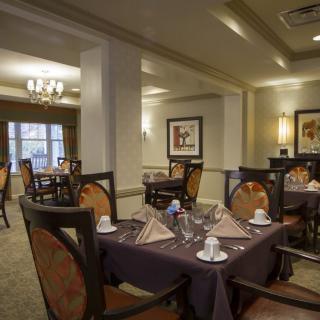 A cozy and elegantly set dining room with tables prepared for guests.