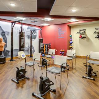 A well-equipped gym space with exercise bikes, boxing bags, and a seating area for group activities.
