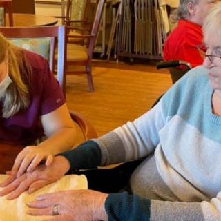 A caregiver assisting an elderly person in a supportive environment.
