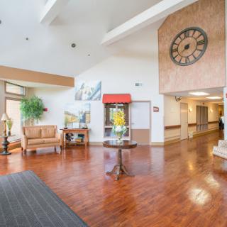 A welcoming lobby area featuring comfortable seating, a decorative clock, and natural light.