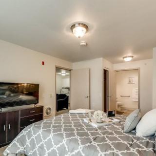 A modern bedroom interior featuring a comfortable bed, a TV, and stylish decor.