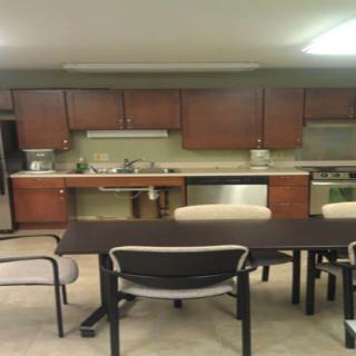 A modern kitchen with wooden cabinets, a dining table, and chairs.