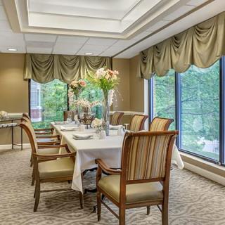 An elegantly decorated dining room with a set table and large windows.