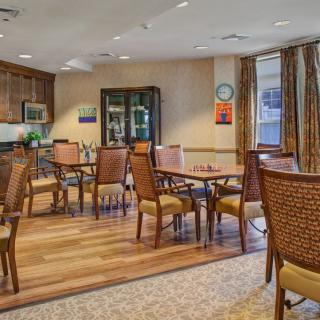 A cozy dining area with wooden tables and chairs, featuring a warm interior design.