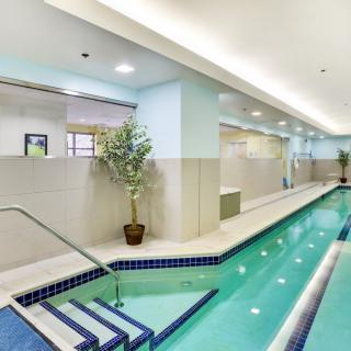 A modern indoor swimming pool with sleek design and bright lighting.
