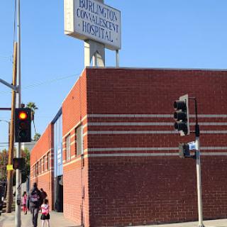 A view of a brick building with a sign, captured on a sunny day.