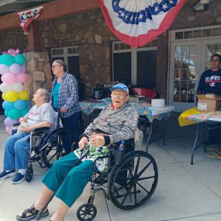Residents enjoying a community celebration outdoors with caregivers.