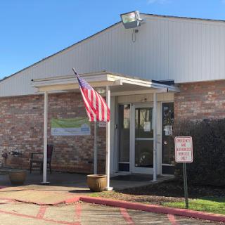 The entrance of a community building displaying an American flag.