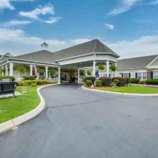 A well-maintained building entrance with a landscaped driveway.
