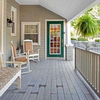 A cozy porch with rocking chairs and a green-bordered front door.