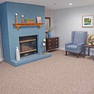 A cozy living room featuring a blue accent wall, a fireplace, and comfortable seating.