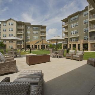 A modern apartment complex featuring outdoor seating and a well-maintained patio area.