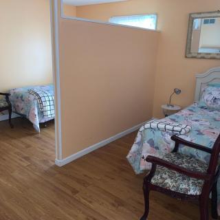A bedroom with two beds separated by a partition wall.