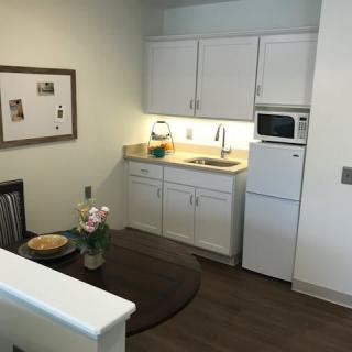 A cozy, minimalist kitchen with white cabinets and a small dining table.