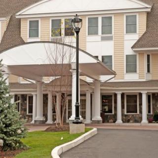 Front entrance of a residential building with a covered driveway.