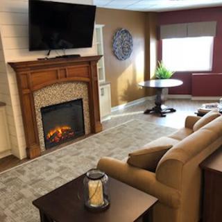A cozy living room with a fireplace, TV, and comfortable seating.
