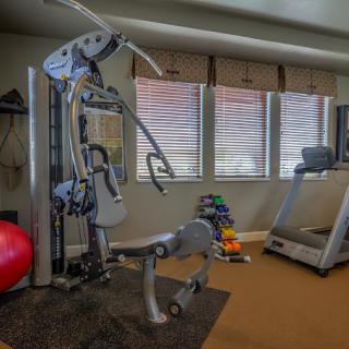 A well-equipped home gym with various exercise machines and workout tools.