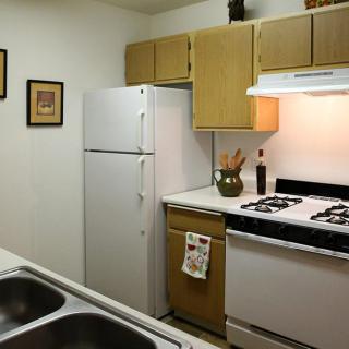 A small kitchen with white appliances and wooden cabinets.