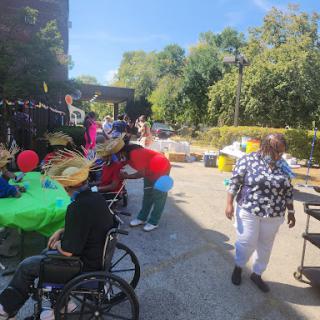 A lively outdoor community event filled with colorful decorations and people enjoying the festivities.