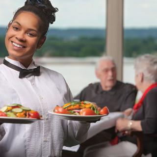 A waitress serves food to customers in a restaurant.