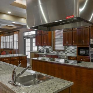 A modern kitchen with granite countertops and stainless steel appliances.