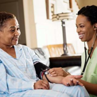 A nurse checking a patient's blood pressure in a home setting.