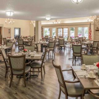 Spacious dining area with neatly arranged tables and chairs, featuring elegant decor and warm lighting.