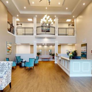 A spacious and elegant lobby with modern furniture and a grand chandelier.