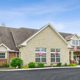 A residential building with a stone facade and well-maintained landscaping.