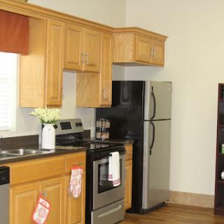 A modern kitchen featuring wooden cabinets and stainless steel appliances.