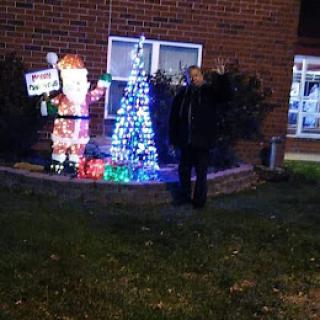 A festive display featuring Santa Claus and a brightly lit Christmas tree.