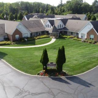 An aerial view of a residential complex with well-maintained lawns and surrounding trees.