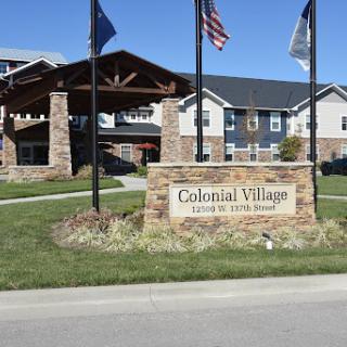 Colonial Village entrance with flags and welcoming signage.