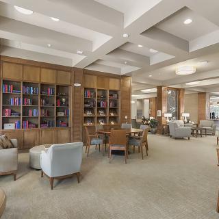A modern library with comfortable seating and an array of bookshelves.