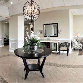 A stylish lobby area with a round table, chandelier, and elegant decor.