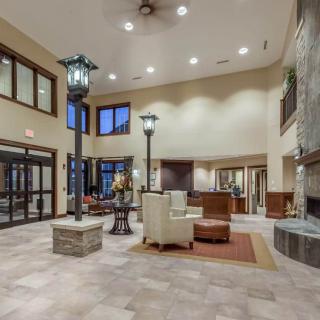 A spacious and elegantly designed hotel lobby with a reception desk, seating area, and fireplace.