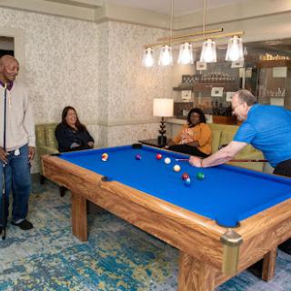 Friends enjoying a game of pool in a cozy indoor setting.