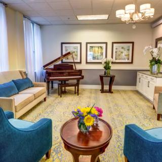 A well-furnished lobby with a piano, comfortable seating, and decorative elements.
