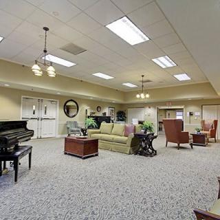 A spacious living area featuring a piano, comfortable seating, and elegant lighting.