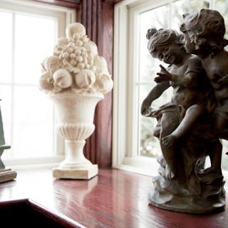 A collection of elegant sculptures placed by a window, showcasing artistic design and home decor.