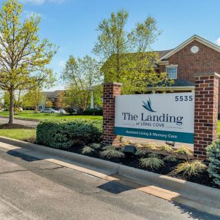 Entrance sign for The Landings apartment complex surrounded by greenery.