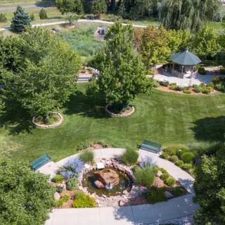 Aerial view of a beautifully landscaped garden featuring a gazebo, pond, and lush greenery.