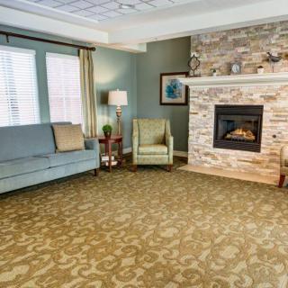 A cozy living room with a stone fireplace and comfortable seating.