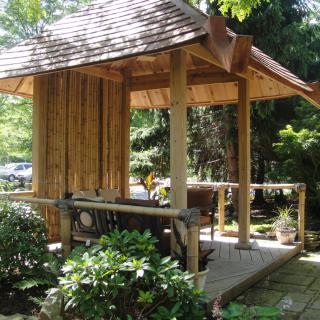 A traditional Japanese garden structure surrounded by lush greenery.