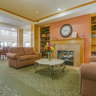 A cozy living room with a fireplace, sofas, and a coffee table adorned with flowers.