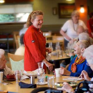 A group of elderly individuals enjoying a meal together in a community dining setting.